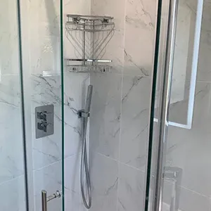 a walk in shower sitting next to a toilet